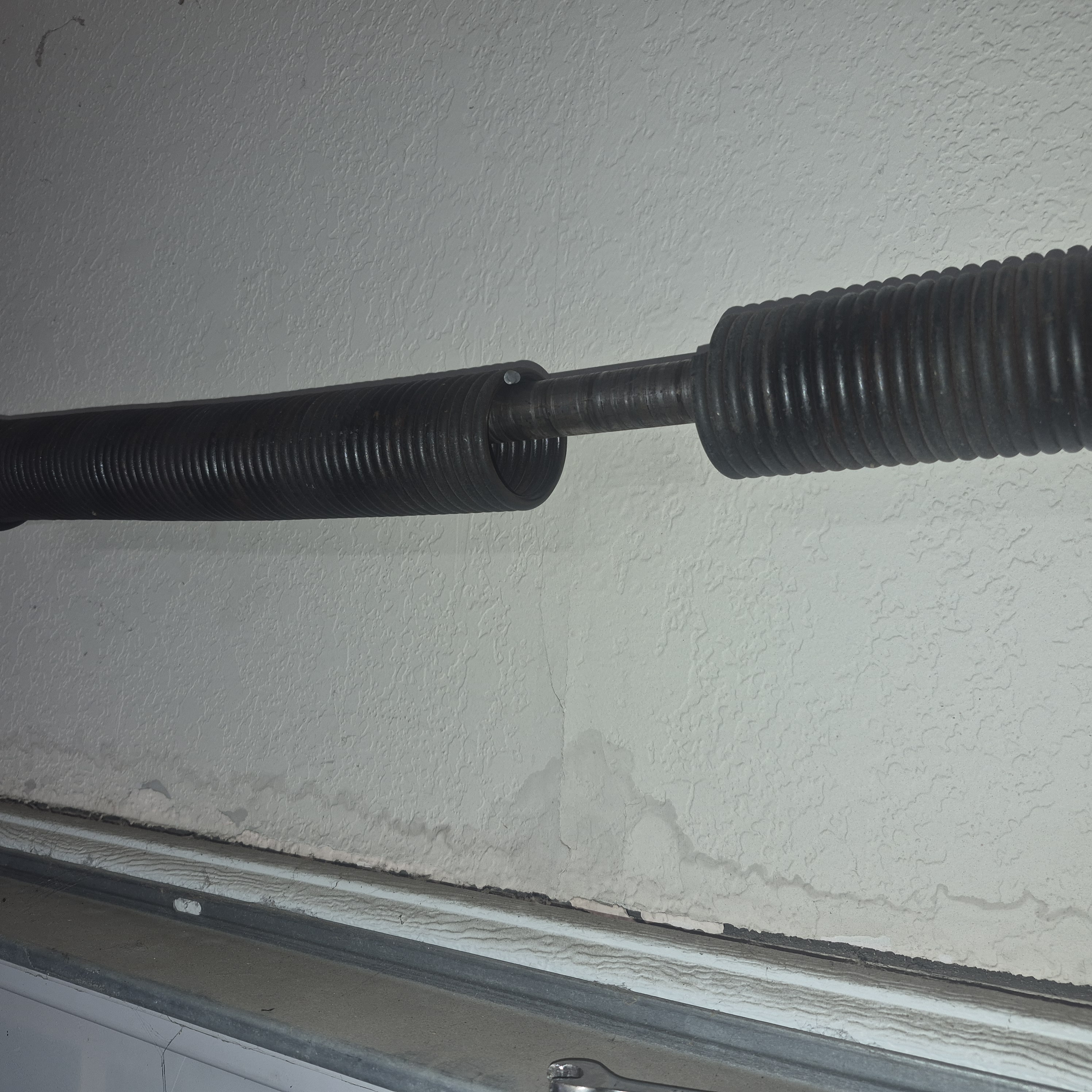 Broken spring and track strain needing garage door off track repair