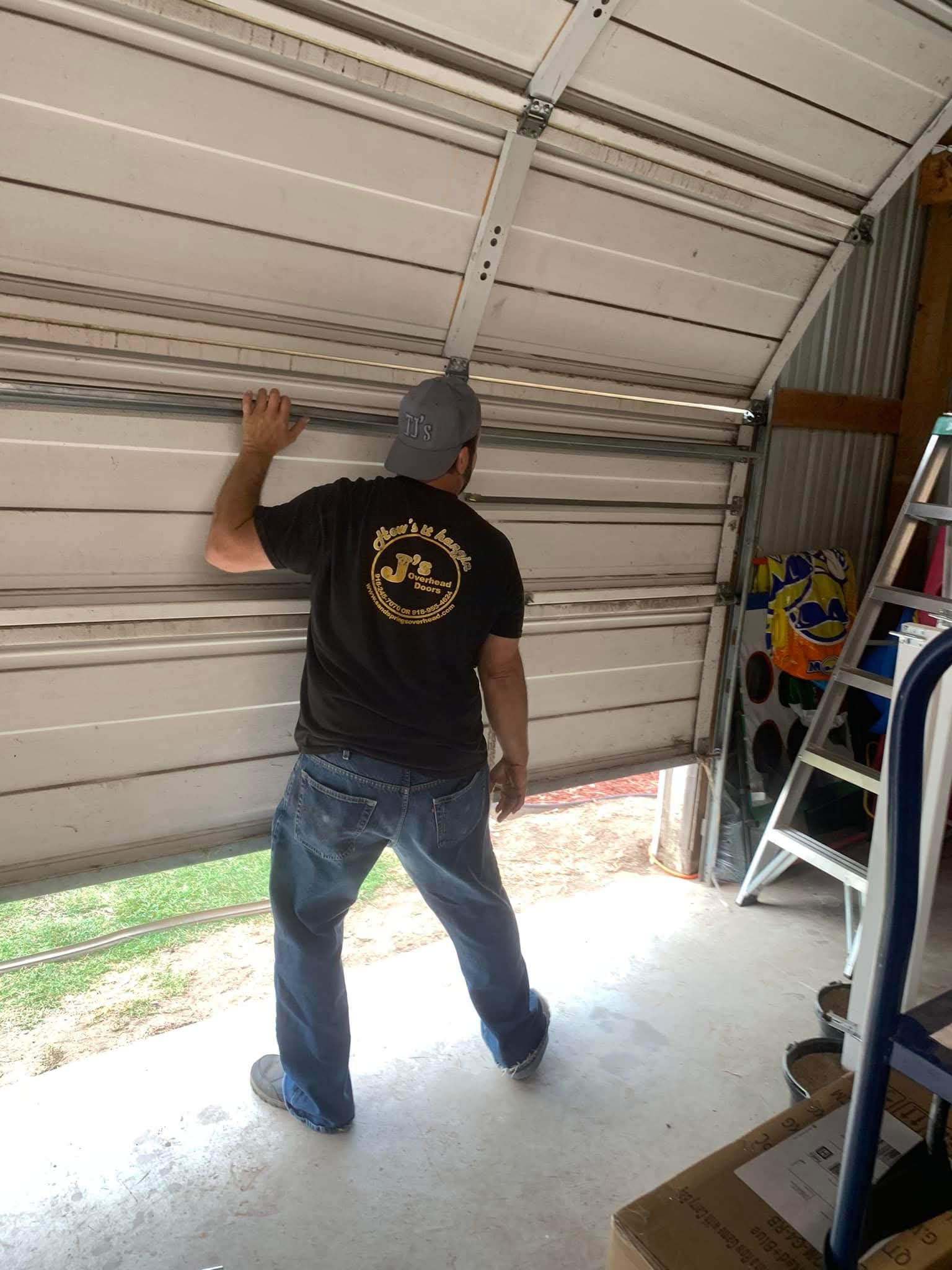 Technician repairing off-track garage door in Sand Springs, OK